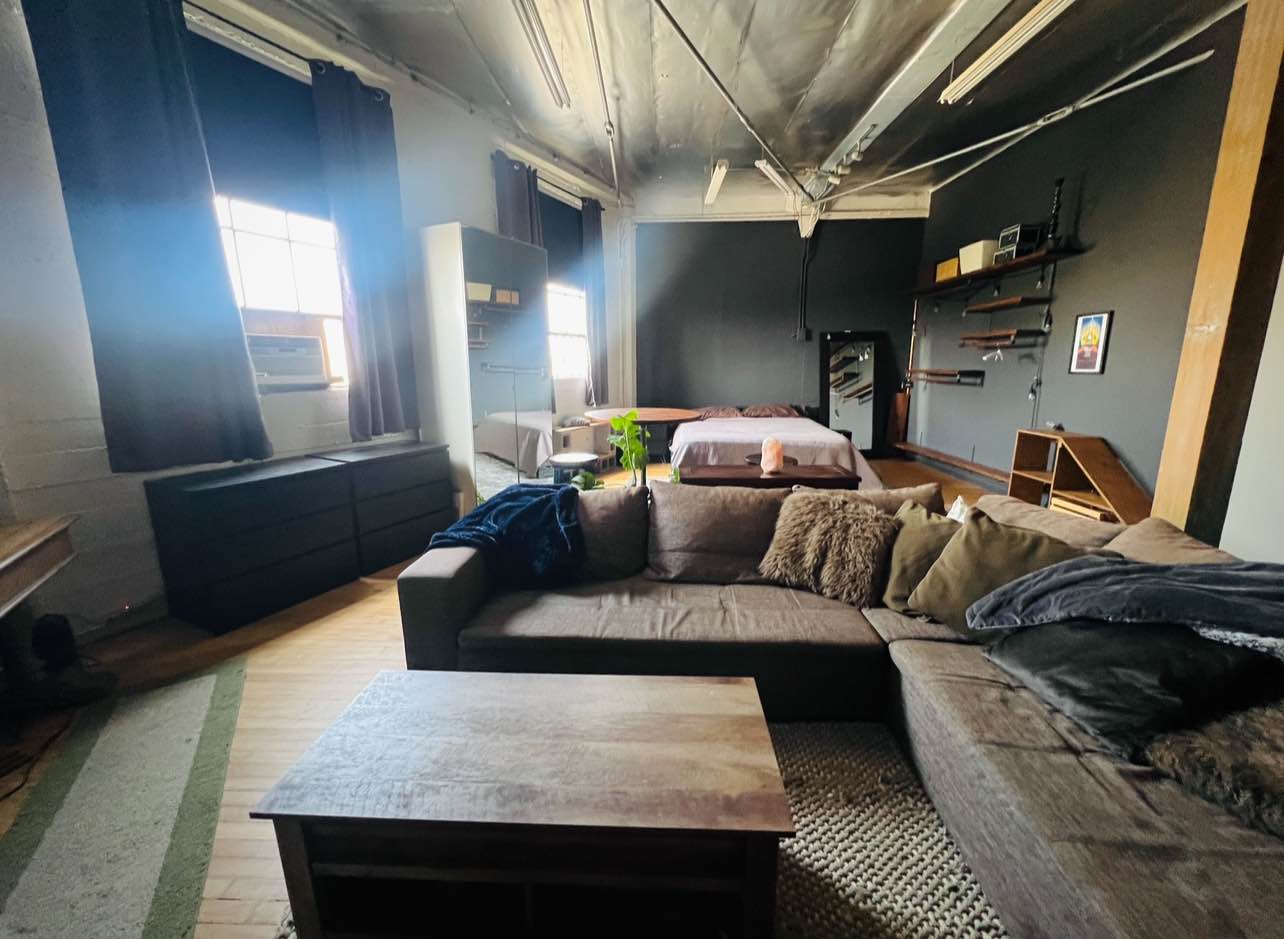 One room available in a beautiful, 4000 square foot loft with three bedrooms. Loft is located in a historic artist community near Downtown Los Angeles. The room is the size of a studio apartment with shared common spaces and 1.5 bathrooms. Home includes wifi, projector with Sonos speaker system, AC, washer/dryer, water, trash, shared electricity, and access to an amazing creative community.

We are looking for someone creative, responsible, respectful, and trustworthy, who enjoys solo time as well as social time. This is a creative haven for anyone who loves art and getting inspired. The room comes unfurnished unless you are interested in purchasing furniture from the previous roommate (furniture pictured). The room comes with an AC unit, huge windows with blackout curtains, and a view of the downtown skyline.

There is a climbing gym on property you can access with a membership, as well as a bar/restaurant and park in the center of the complex. It's an incredibly unique place to live, and I've been here since 2018. I spend a lot of time writing in my room, I love watching movies, and am otherwise traveling. The other roommate is also female and a creative!
