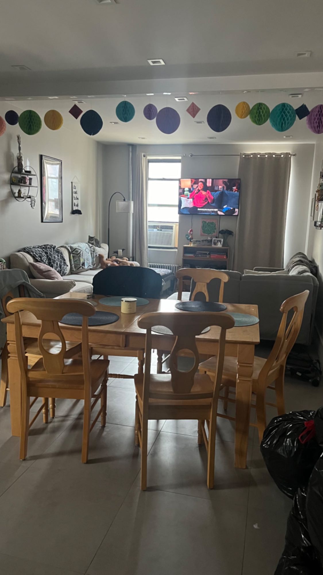 The neighborhood is nice. Rather quiet. The unit is a large three bedroom of which I am looking to fill two rooms. One room is the largest room, and the other is the smallest room. I occupy the medium sized room. We have in unit laundry. With a large living room and dining area and good sized kitchen. The super and landlord are attentive and timely to any issues we have had. I do have a small dog and cat.