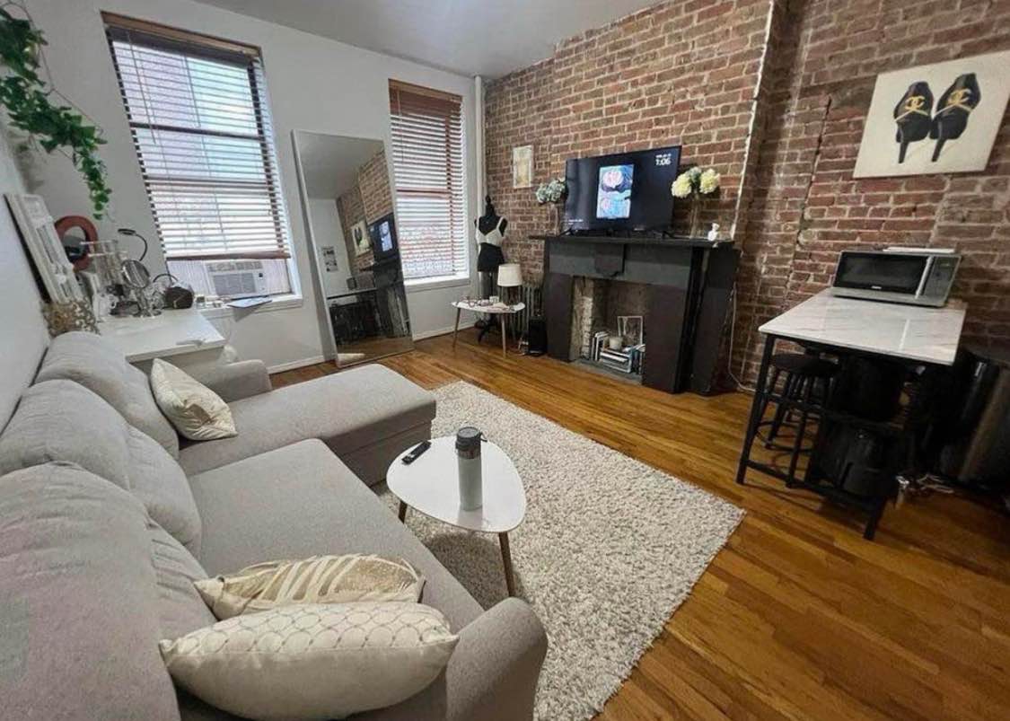 This is a fantastic place with two great living space.

The main living area is bright and features nice hardwood floors. In one setup, you get an incredible exposed brick wall and a decorative fireplace, adding huge character! The space is large enough for a comfy sectional couch and a separate dining setup.

The kitchen is modern and functional, cabinets and stainless steel appliances.

The bedroom is cozy and bright, with enough space for a queen bed and great natural light. Has built-in closet space and is spacious enough for a vanity or desk.

The bathroom has great style! This apartment is full of personality and is a truly comfortable place to call home.

Send a message to schedule viewing