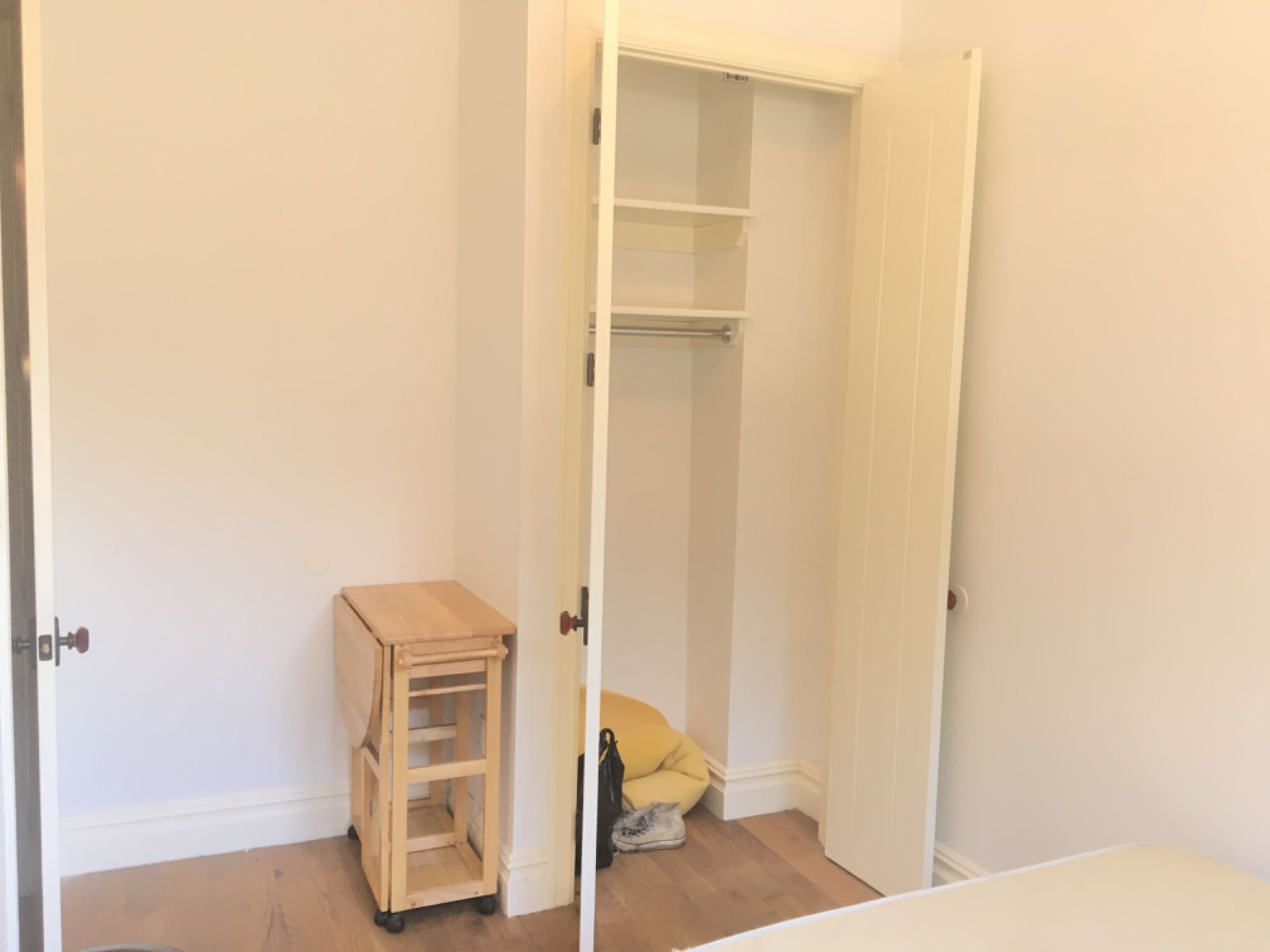 We have a 3-bedroom apartment and are looking for someone to fill one of those rooms from June 15 to November 15 (or November 1). Rent is $900, due before the first of each month. To move in, we need $450 for the second half of June plus a one-month security deposit. Utilities are $125-150 per month.

The first-floor split-level apartment is a short walk to the Central M station and a 10-minute walk to both the DeKalb L and Kosciusko J stations. It has two floors, with the room on the upper level, about half a floor above ground level, so people on the street can’t look directly in.

The room has a huge south-facing window and a medium-size closet with built-in shelving for storage. The room comes furnished with a bed frame and mattress—but if you don’t need these, we can work something out. It has room for a dresser or desk and a small bookshelf. Also on the upper level are a well-stocked kitchen (with dishwasher and TV), bathroom, and the second bedroom. The third bedroom (with its own half bathroom) is on the lower level.

The building has central AC; three washer/dryer units; a backyard space with bike racks; a roof with a grill and tons of seating; a common room with a giant TV, a couch, and a pool/ping pong table; and a gym with the standard equipment. The building is next to the above-ground M train. We are moderate sleepers, and the noise from the train hasn’t bothered our sleep at all. It’s easy to get used to.